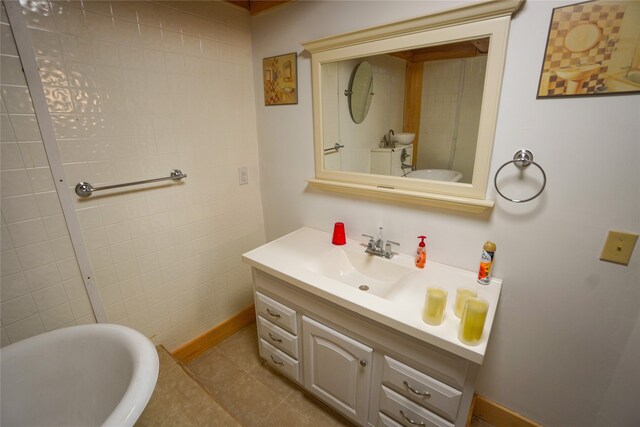 bathroom with tile flooring, vanity, and a bath