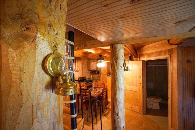 corridor with wood ceiling, beam ceiling, and wood walls