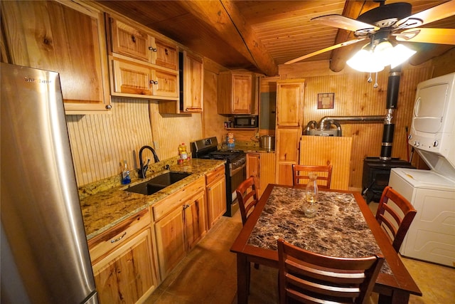 kitchen with stainless steel fridge, ceiling fan, sink, range, and stone countertops