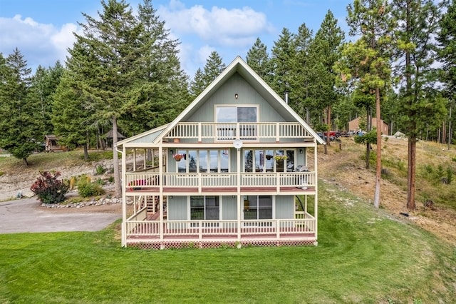 rear view of property with a lawn and a balcony