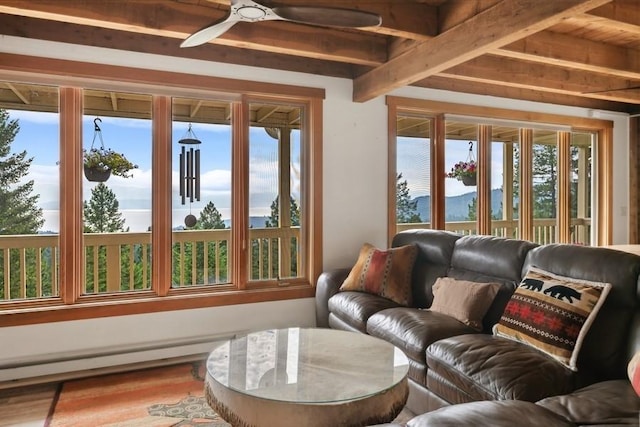 sunroom / solarium featuring a ceiling fan, a baseboard radiator, and plenty of natural light