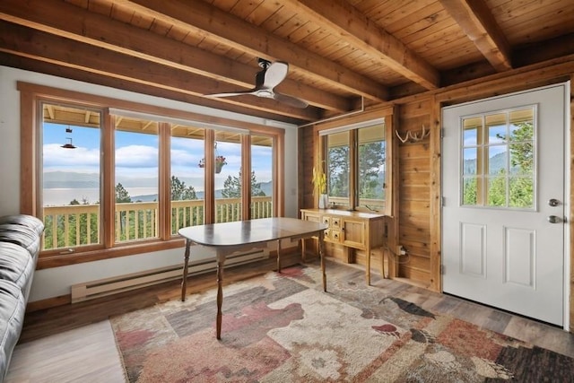 sunroom with a baseboard radiator, a mountain view, wood ceiling, a ceiling fan, and beamed ceiling