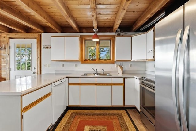 kitchen with a peninsula, appliances with stainless steel finishes, and white cabinetry