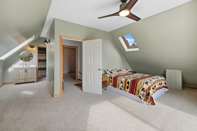 bedroom featuring vaulted ceiling with skylight, light colored carpet, and radiator heating unit