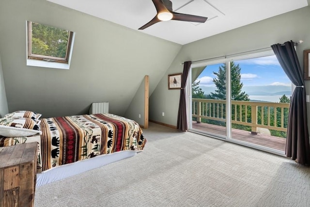 carpeted bedroom featuring lofted ceiling with skylight, access to outside, baseboards, and ceiling fan