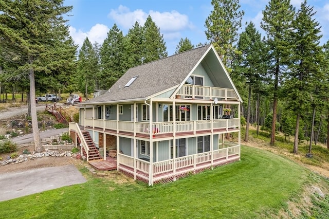 rear view of property with a balcony and a yard