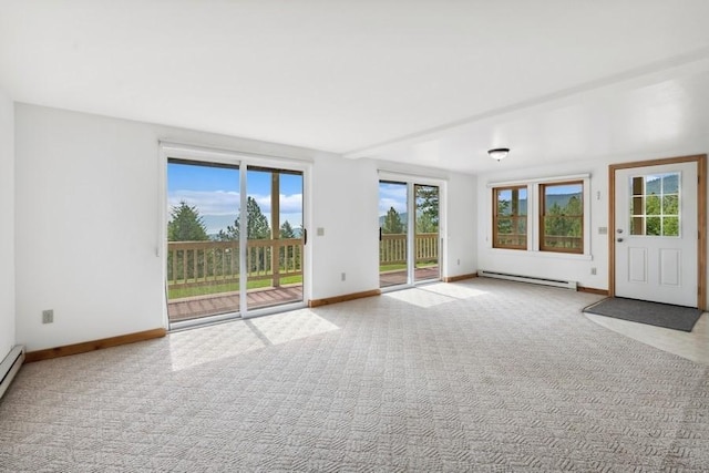 interior space featuring light carpet, a baseboard heating unit, baseboard heating, and baseboards