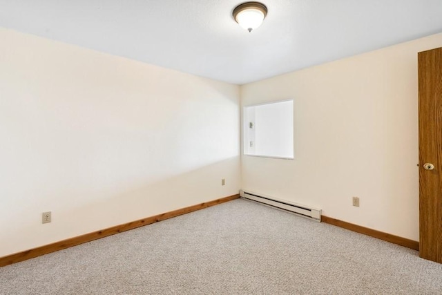 spare room with baseboard heating, carpet, and baseboards