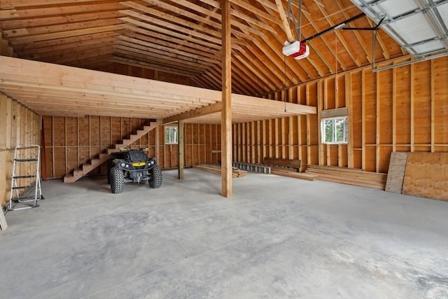 miscellaneous room featuring vaulted ceiling, a garage, and concrete flooring