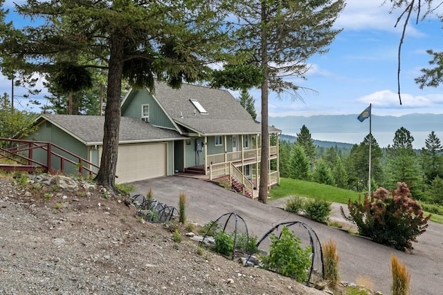 view of front of house with aphalt driveway, a shingled roof, stairway, a mountain view, and a garage