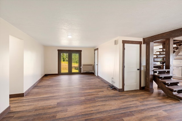 spare room with french doors, dark wood-type flooring, and radiator heating unit