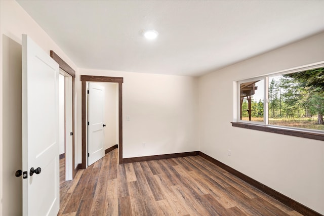 unfurnished room with dark wood-type flooring