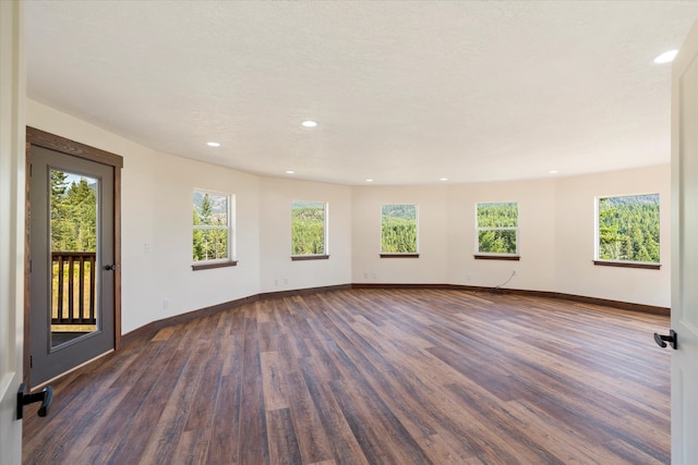 unfurnished room with dark wood-type flooring and a wealth of natural light