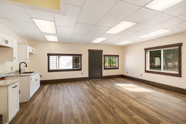 kitchen with sink, a drop ceiling, dark wood-type flooring, and white cabinetry