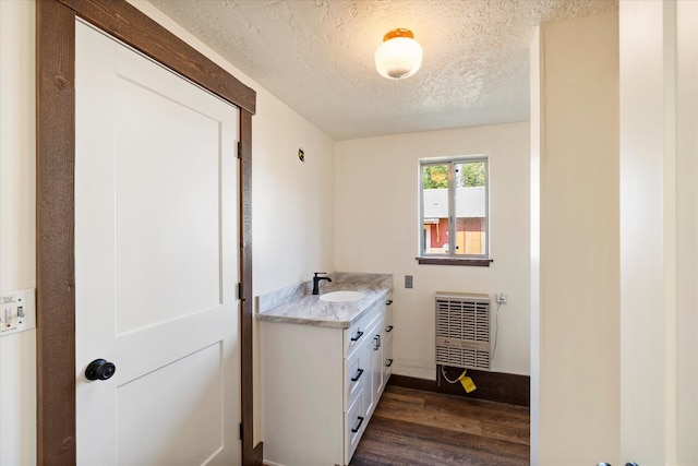 bathroom with radiator, a textured ceiling, vanity, and wood-type flooring