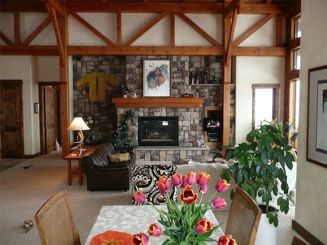 living room featuring beamed ceiling, a stone fireplace, carpet flooring, and high vaulted ceiling