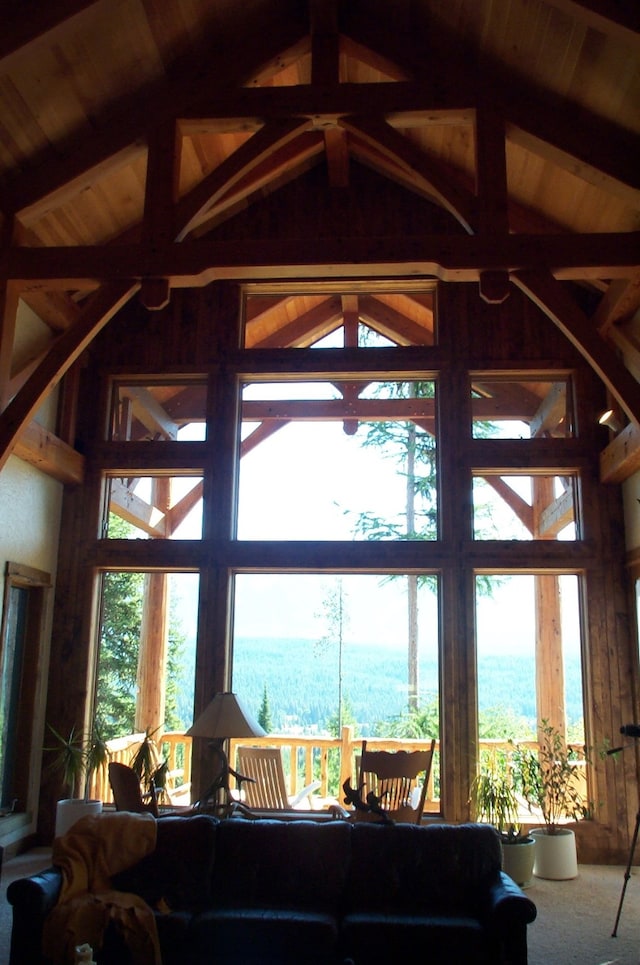 carpeted living room with wooden ceiling, beamed ceiling, and high vaulted ceiling