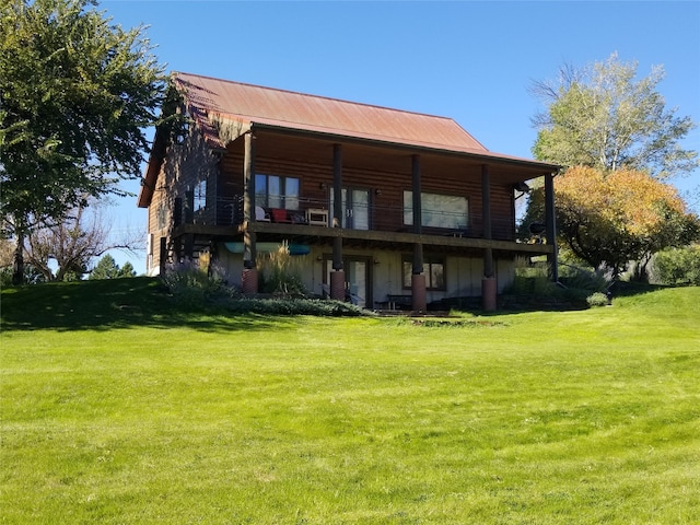 back of property with a yard and a balcony