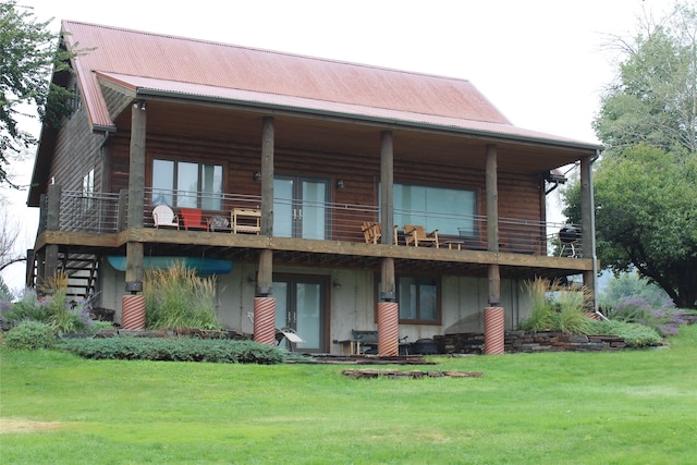 back of house featuring a yard and a balcony