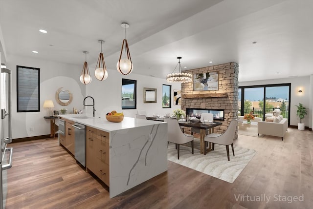 311 Akers Ln Unit D, Whitefish, MT 59937 - kitchen with a sink, dishwasher, light wood finished floors, a stone fireplace, and open floor plan