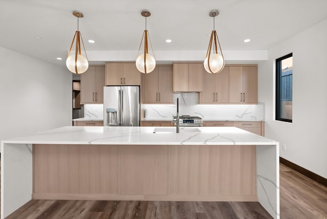 kitchen with stainless steel appliances, light stone counters, and light brown cabinetry