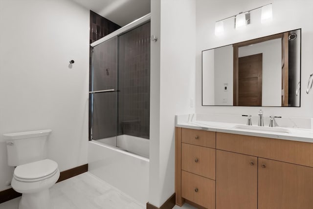 bathroom featuring baseboards, enclosed tub / shower combo, vanity, and toilet