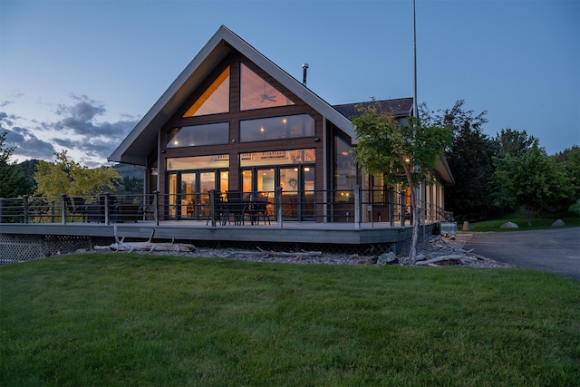 rear view of house with a wooden deck, central air condition unit, and a yard