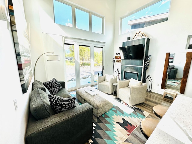 living room featuring hardwood / wood-style flooring, a high ceiling, and french doors