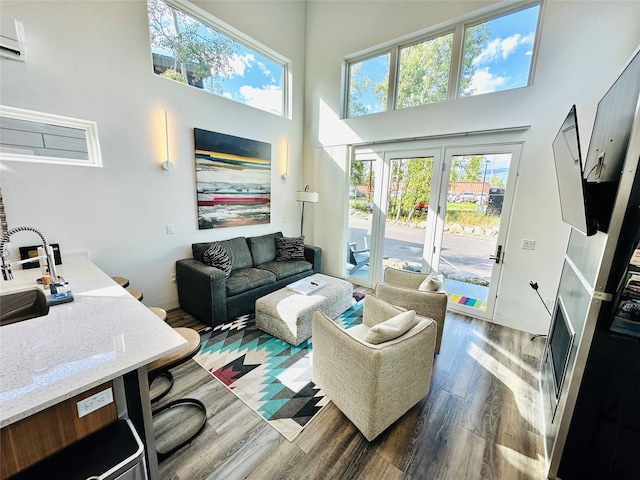 living room with dark wood-type flooring and a towering ceiling