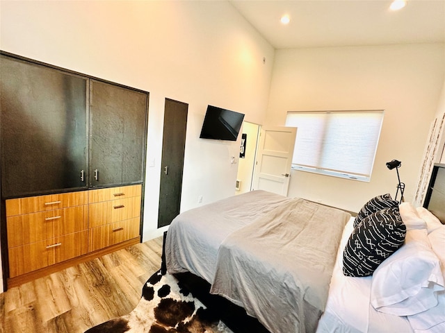 bedroom with light hardwood / wood-style floors and vaulted ceiling