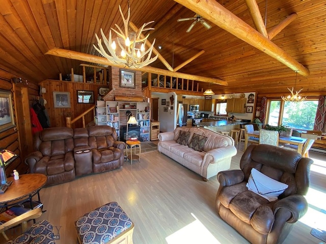 living room featuring wooden walls, light hardwood / wood-style floors, wooden ceiling, ceiling fan with notable chandelier, and vaulted ceiling with beams