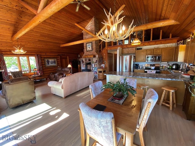 dining space featuring sink, wood ceiling, light hardwood / wood-style flooring, rustic walls, and ceiling fan with notable chandelier