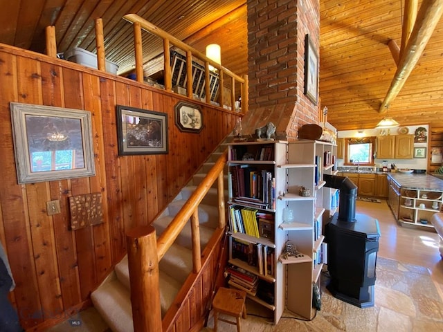 stairway with brick wall, wood ceiling, wooden walls, and a wood stove