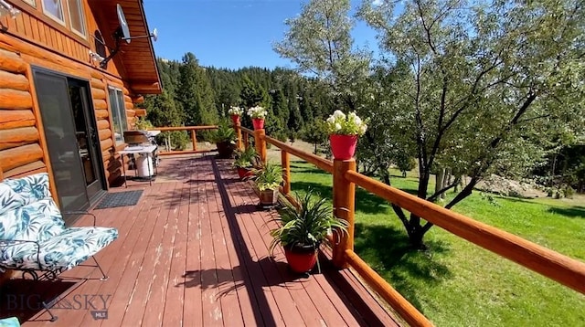 wooden deck featuring a grill and a lawn