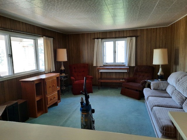 carpeted living room featuring wooden walls and a healthy amount of sunlight