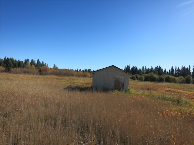 view of yard featuring a rural view and an outbuilding