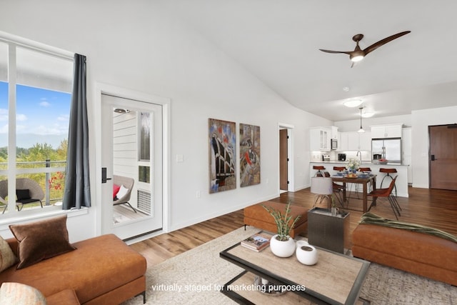 living room featuring high vaulted ceiling, hardwood / wood-style floors, and ceiling fan