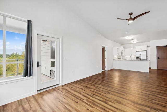 unfurnished living room featuring sink, ceiling fan, vaulted ceiling, and dark hardwood / wood-style flooring