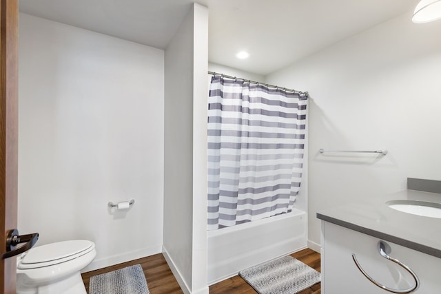 full bathroom with shower / tub combo with curtain, vanity, toilet, and hardwood / wood-style floors