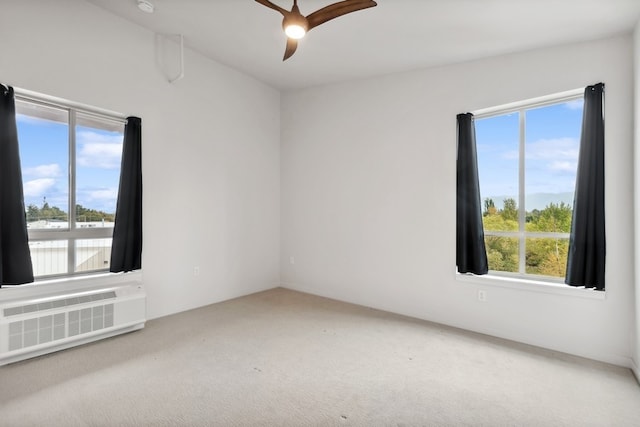 spare room featuring a healthy amount of sunlight, carpet, and ceiling fan