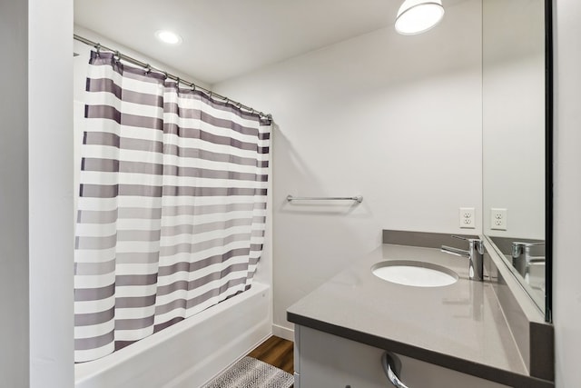 bathroom featuring shower / bathtub combination with curtain, hardwood / wood-style flooring, and vanity