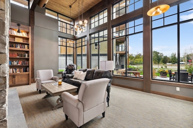 living room featuring a notable chandelier, built in features, a high ceiling, and wood ceiling