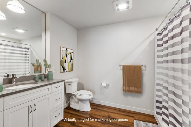 bathroom featuring vanity with extensive cabinet space, toilet, and hardwood / wood-style flooring