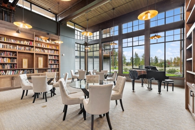 dining room with light colored carpet, wooden ceiling, a high ceiling, and beam ceiling