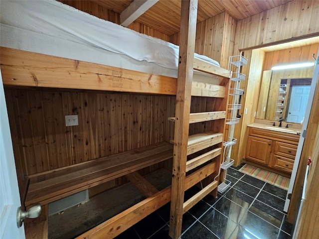 bedroom featuring sink, wooden walls, and wooden ceiling