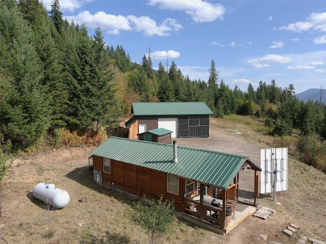 rear view of property with an outdoor structure