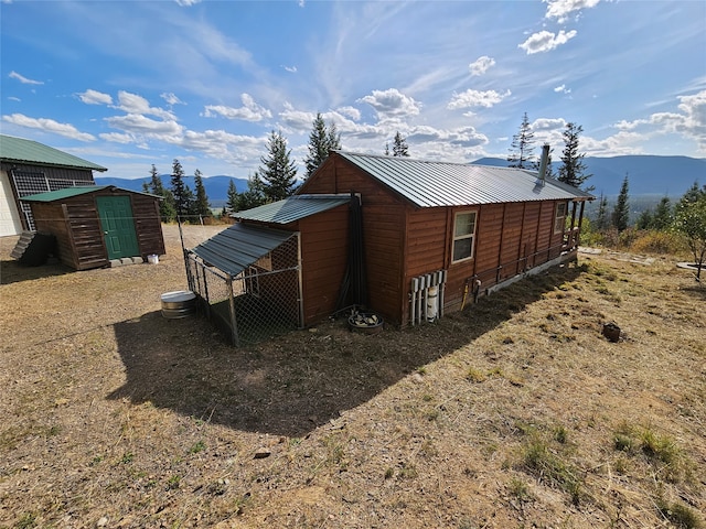 view of side of property with a mountain view and an outdoor structure