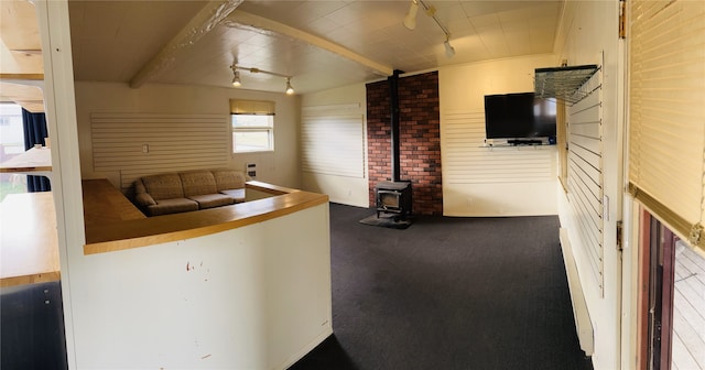 kitchen with lofted ceiling, track lighting, carpet, and brick wall