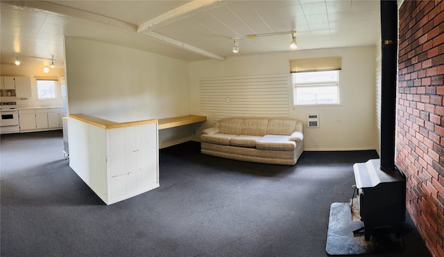 unfurnished office featuring plenty of natural light, brick wall, and track lighting