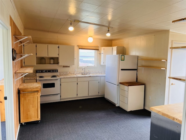 kitchen featuring sink, track lighting, dark colored carpet, and white appliances